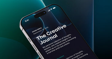 Phone displaying Adam Ingle's 'The Creative Journal' blog on a dark background